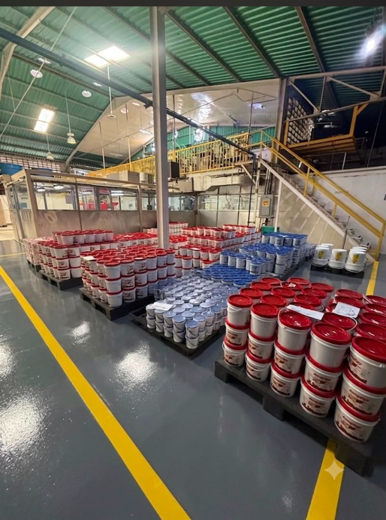 Lotes de arequipe listos para despacho, organizados por presentación, en la planta de Maracay